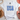 White t-shirt with 'USA' text in blue stars on a light surface with decorative items.