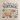 A cream canvas tote bag with brown leather handles, featuring a vintage-style graphic print that reads 'You had me at VINTAGE' above illustrated teacups, flowers, and retro objects. The bag is displayed on a wooden surface against a white wall with eucalyptus branches in the background.