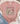 Pink t-shirt with vintage-themed design featuring cups and flowers, placed on a textured surface with jeans and sneakers.